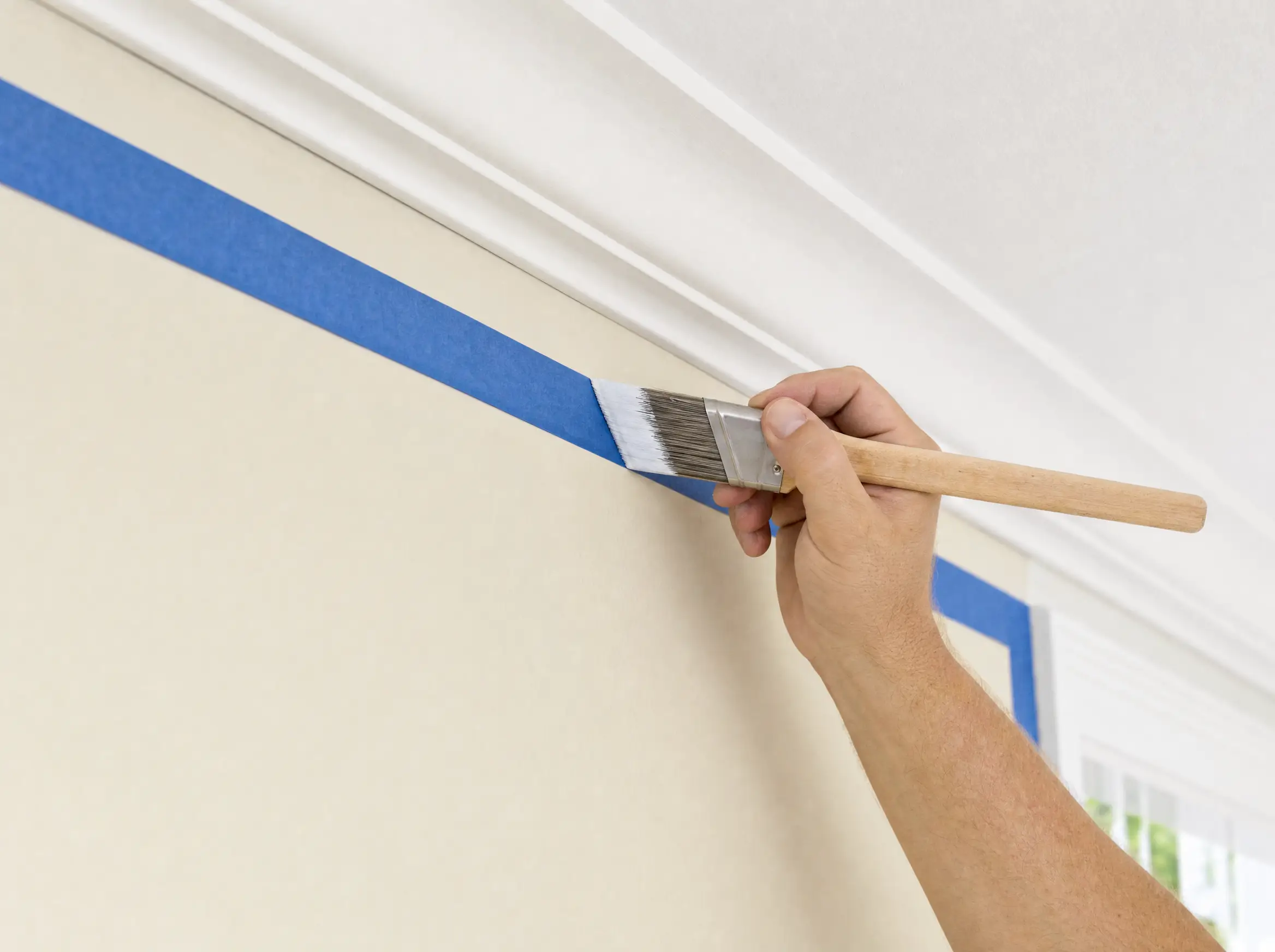 Painter cutting in a clean line on an interior wall